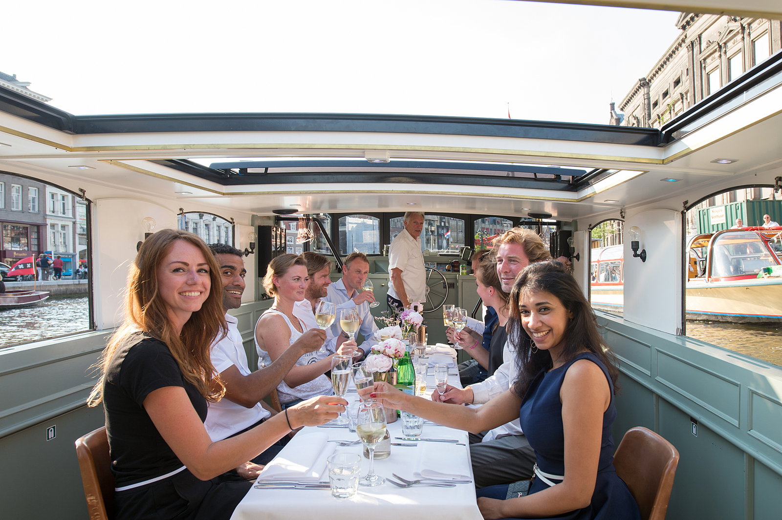 Collega's aan tafel aan boord tijdens een bedrijfsuitje in Amsterdam