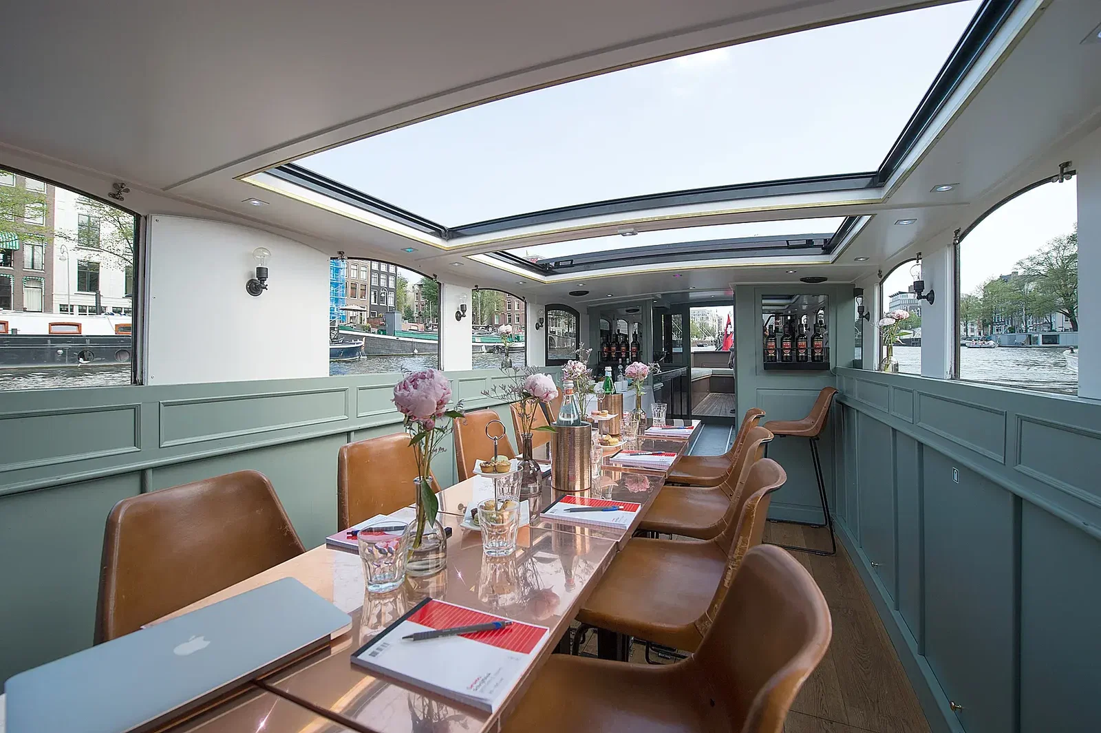 Zakelijke opstelling met gedekte tafels in een salonboot in Amsterdam
